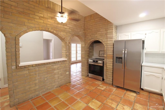2115 Ichabod Ln, Edinburg, TX 78539 - kitchen featuring appliances with stainless steel finishes, white cabinetry, light countertops, brick wall, and recessed lighting