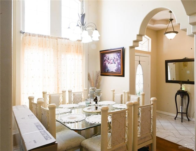 tiled dining room featuring a chandelier