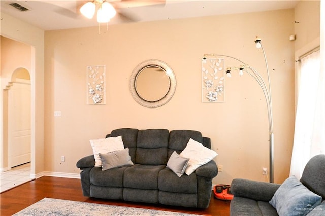 living room with ceiling fan and dark wood-type flooring