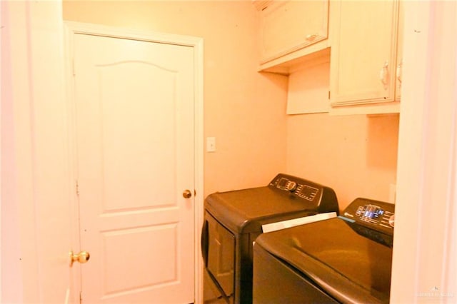 clothes washing area with cabinets and independent washer and dryer