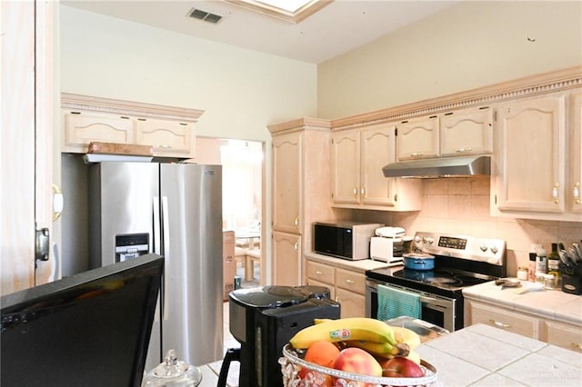 kitchen featuring tile countertops, backsplash, and stainless steel appliances