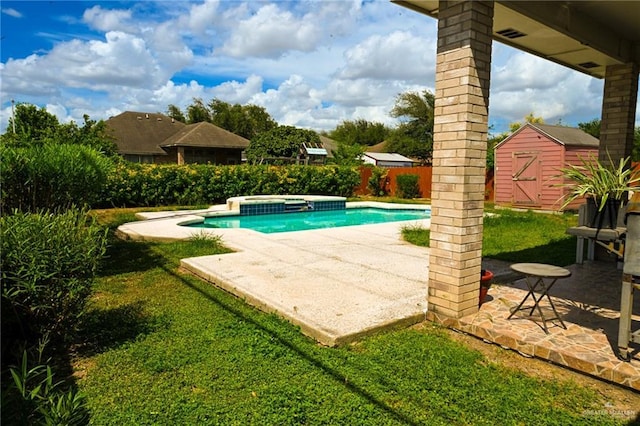 view of swimming pool featuring a lawn, a patio area, an in ground hot tub, and a storage shed