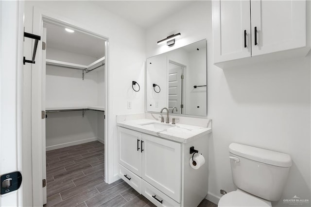 bathroom with vanity, toilet, and wood-type flooring