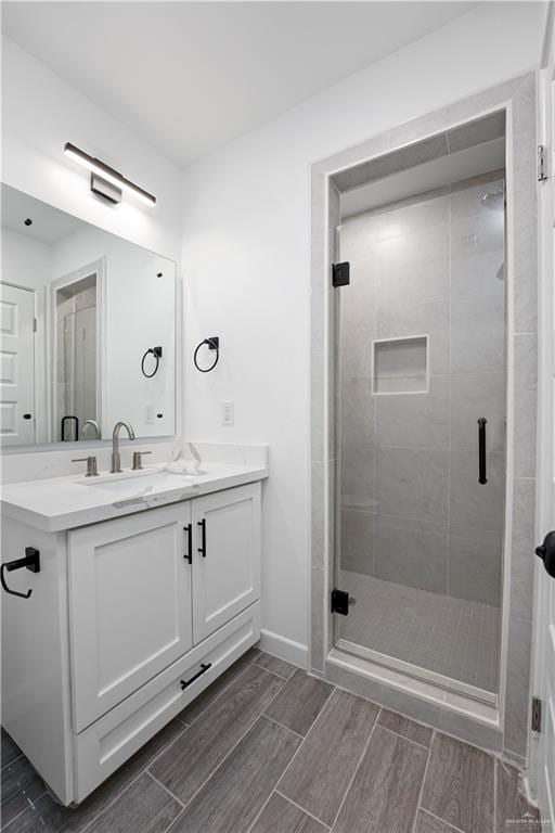 bathroom featuring vanity and a shower with shower door