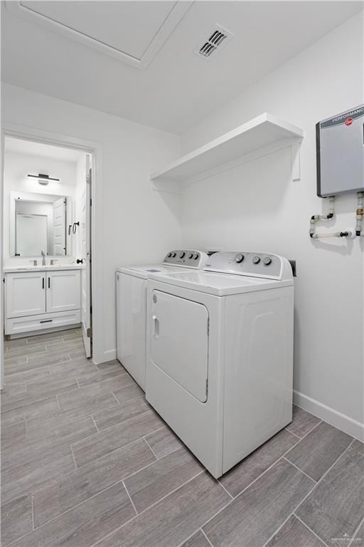 laundry room featuring water heater and washing machine and clothes dryer