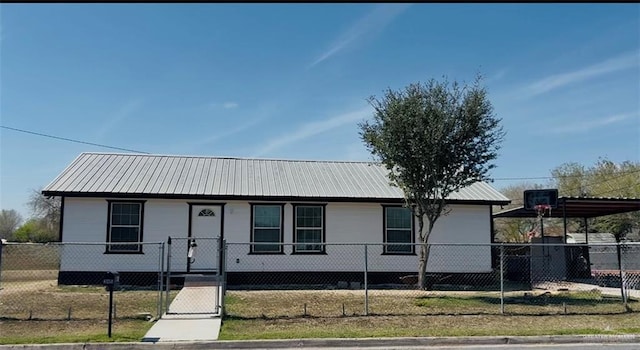 ranch-style house featuring a fenced front yard, a gate, and metal roof