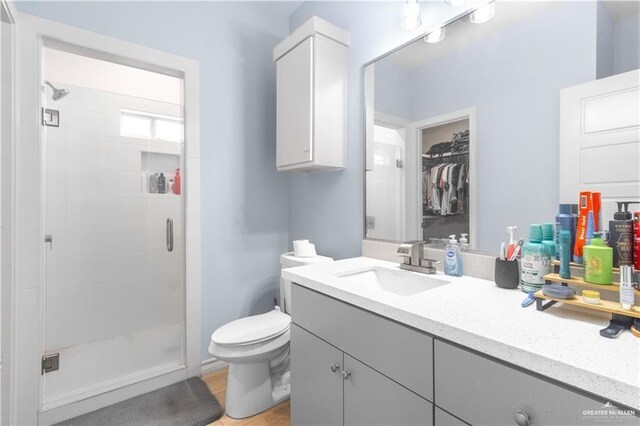 3301 S Colt Ln, Edinburg, TX 78539 - full bath with a stall shower, toilet, vanity, wood finished floors, and a walk in closet