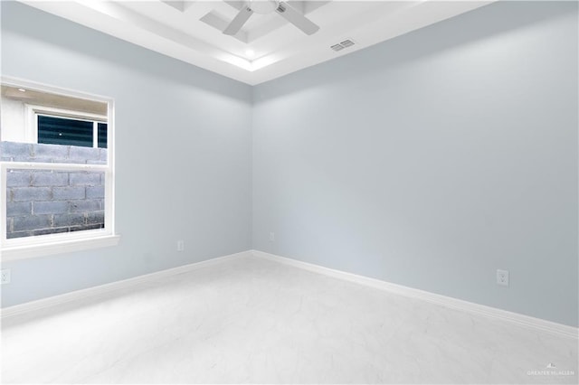 spare room featuring visible vents, baseboards, a raised ceiling, and ceiling fan