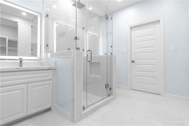 full bath with a stall shower, baseboards, vanity, and recessed lighting