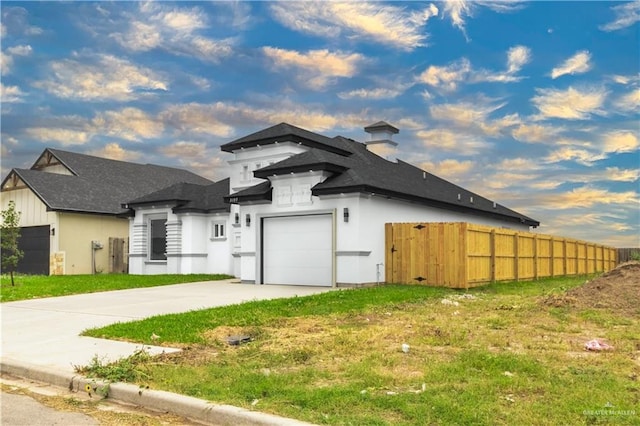 view of front of property with fence, a shingled roof, concrete driveway, and a front yard