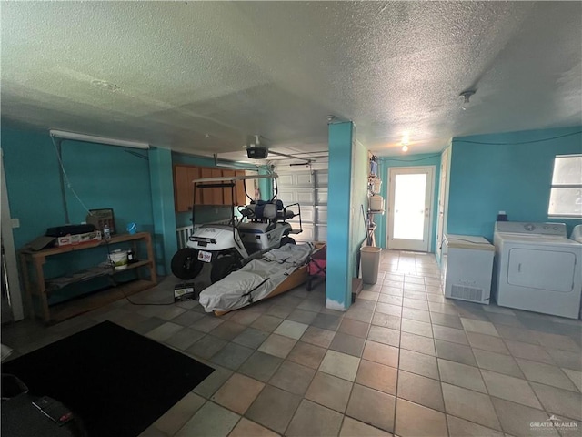 kitchen with a textured ceiling, washer and clothes dryer, and light tile patterned flooring