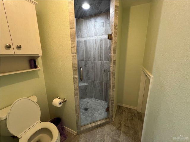 full bath featuring a textured wall, a stall shower, toilet, and baseboards