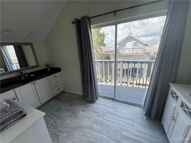 bathroom featuring baseboards, vanity, and a healthy amount of sunlight