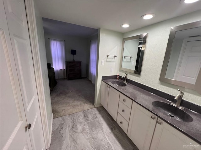 full bath featuring double vanity, a sink, and ensuite bathroom