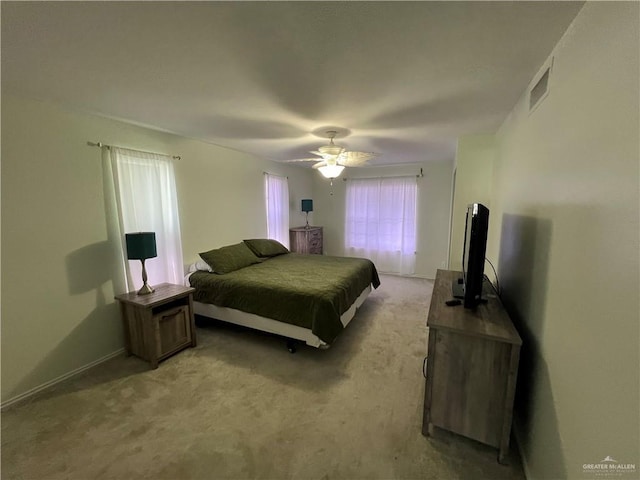 bedroom featuring light carpet, ceiling fan, and visible vents