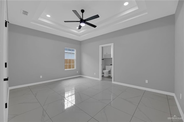 spare room featuring ceiling fan and a tray ceiling