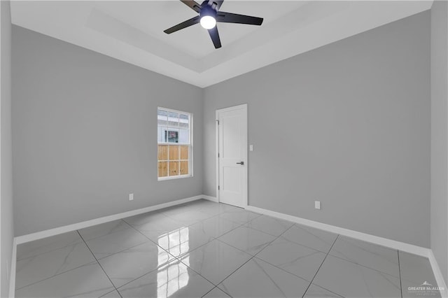 spare room featuring ceiling fan and a tray ceiling