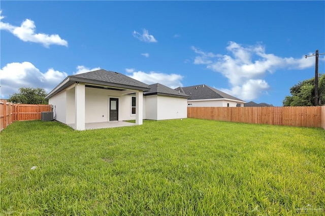 rear view of property featuring cooling unit, a patio area, and a lawn