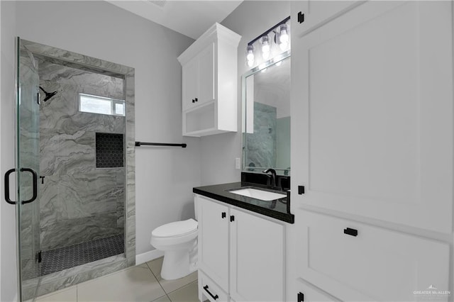 bathroom featuring vanity, tile patterned flooring, toilet, and walk in shower