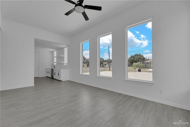 unfurnished living room with ceiling fan and sink