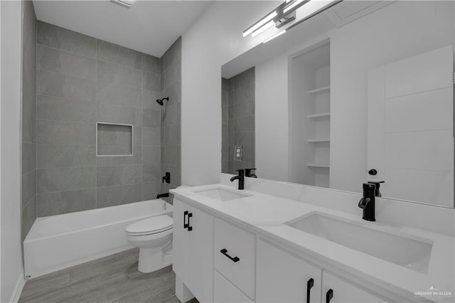 full bathroom featuring wood-type flooring, vanity, toilet, and tiled shower / bath