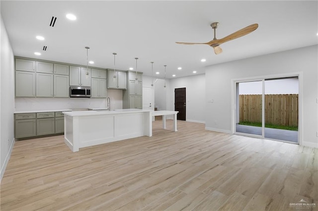 2615 E Solar Dr, Mission, TX 78574 - kitchen with stainless steel microwave, gray cabinetry, a ceiling fan, recessed lighting, and light wood-style floors