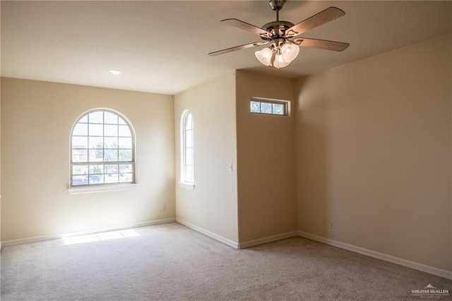 carpeted spare room featuring ceiling fan