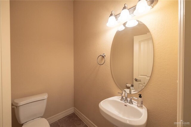 bathroom featuring tile patterned floors, toilet, and sink