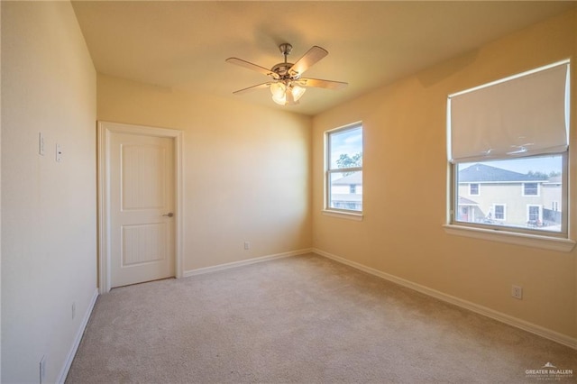 carpeted spare room with ceiling fan