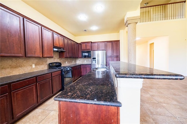 kitchen featuring backsplash, sink, an island with sink, and black appliances