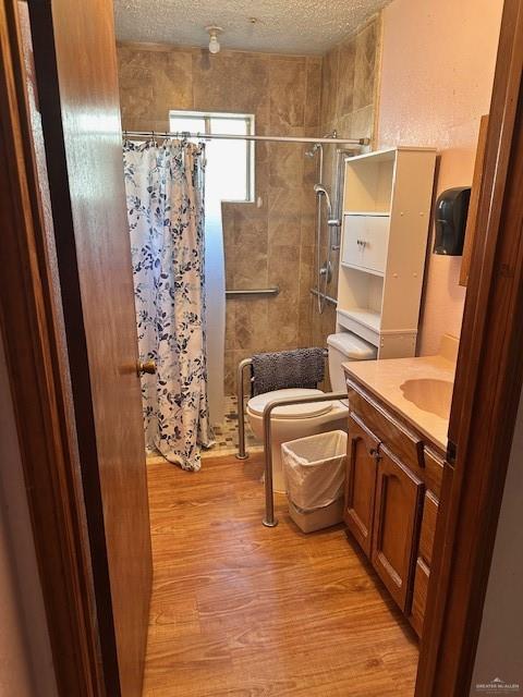 bathroom featuring vanity, hardwood / wood-style floors, toilet, and a textured ceiling