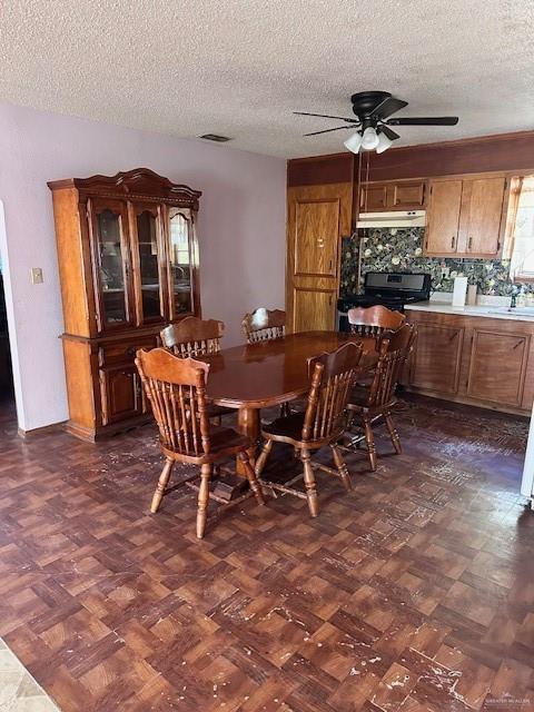 dining area with a textured ceiling and ceiling fan