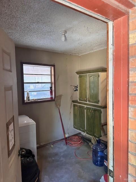 interior space featuring washer / clothes dryer, concrete floors, and a textured ceiling