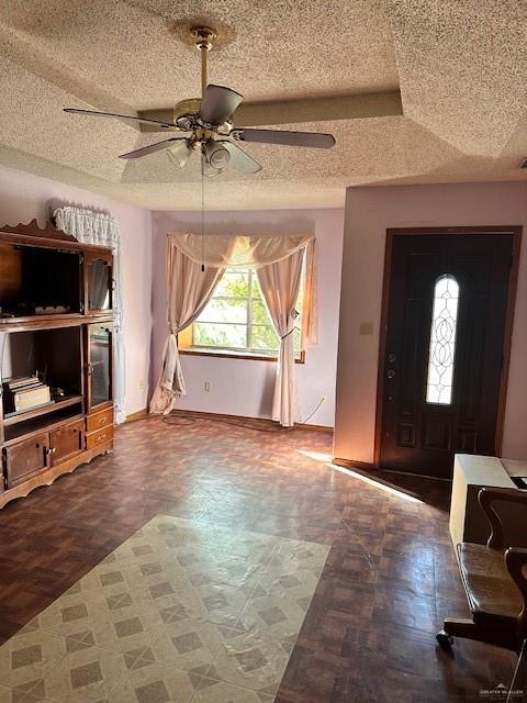 entryway with ceiling fan and a textured ceiling