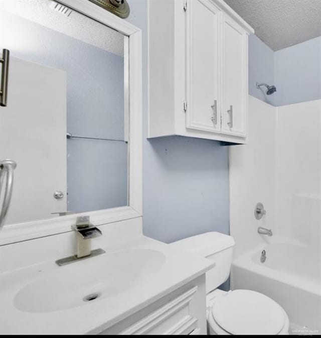 full bathroom with vanity, a textured ceiling, bathing tub / shower combination, and toilet