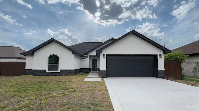 ranch-style home with an attached garage, fence, stone siding, stucco siding, and a front lawn