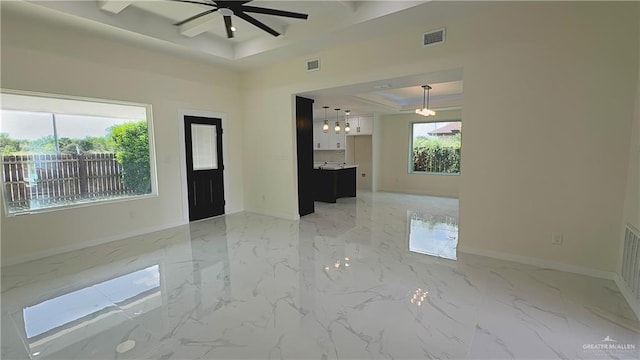 empty room featuring marble finish floor, visible vents, a tray ceiling, and baseboards