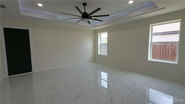 unfurnished room with baseboards, a raised ceiling, and recessed lighting