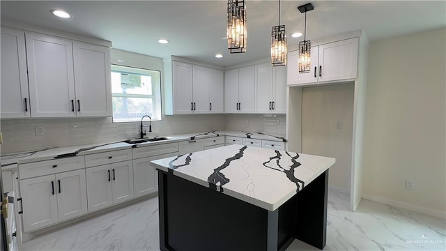 kitchen featuring marble finish floor, light stone counters, a sink, and decorative backsplash