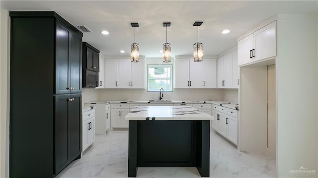 kitchen with marble finish floor, light countertops, a sink, and recessed lighting