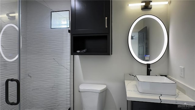 bathroom with toilet, a shower stall, and vanity