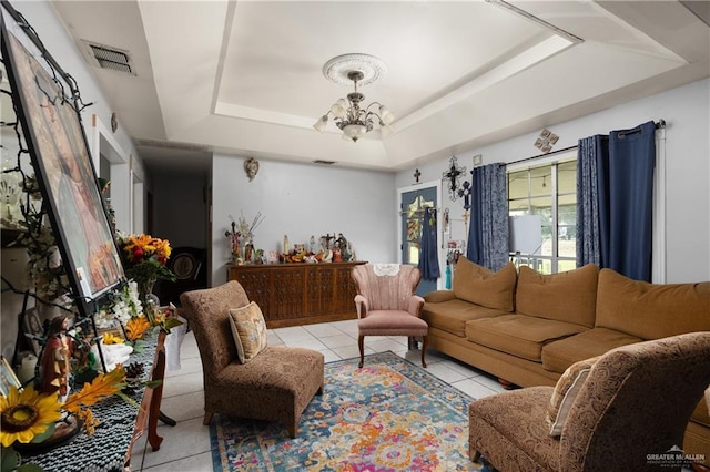 tiled living room featuring a raised ceiling and a notable chandelier