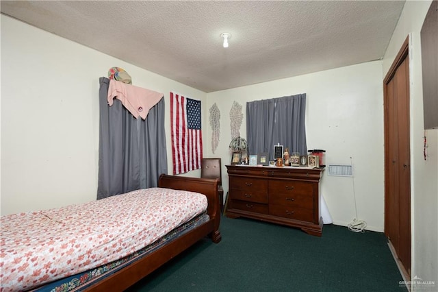 bedroom with a closet, a textured ceiling, and dark colored carpet