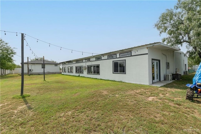 10766 N Minnesota Rd, Mission, TX 78574 - rear view of house featuring a lawn, stucco siding, and central AC