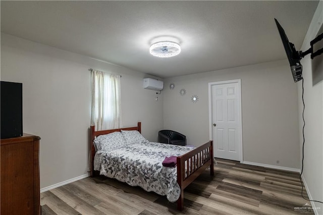 10766 N Minnesota Rd, Mission, TX 78574 - bedroom featuring wood finished floors, a wall unit AC, and baseboards