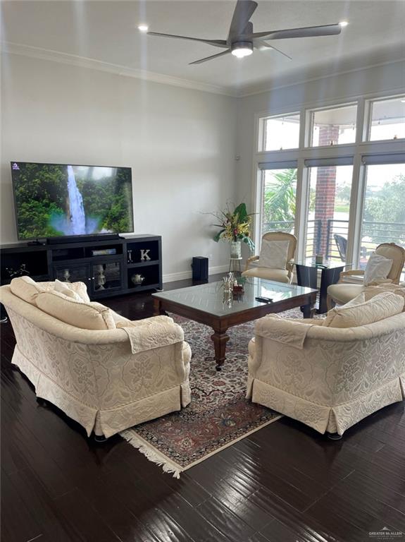 living room with ceiling fan, wood-type flooring, and ornamental molding