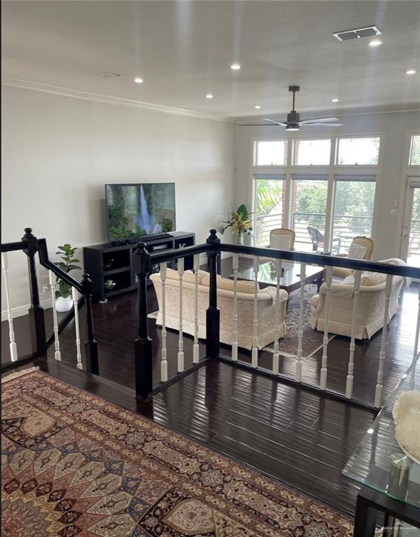 interior space with dark hardwood / wood-style floors, ceiling fan, and ornamental molding