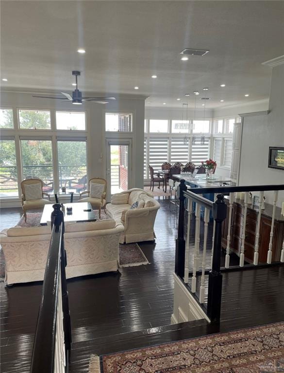 living room featuring hardwood / wood-style floors, ceiling fan, and ornamental molding