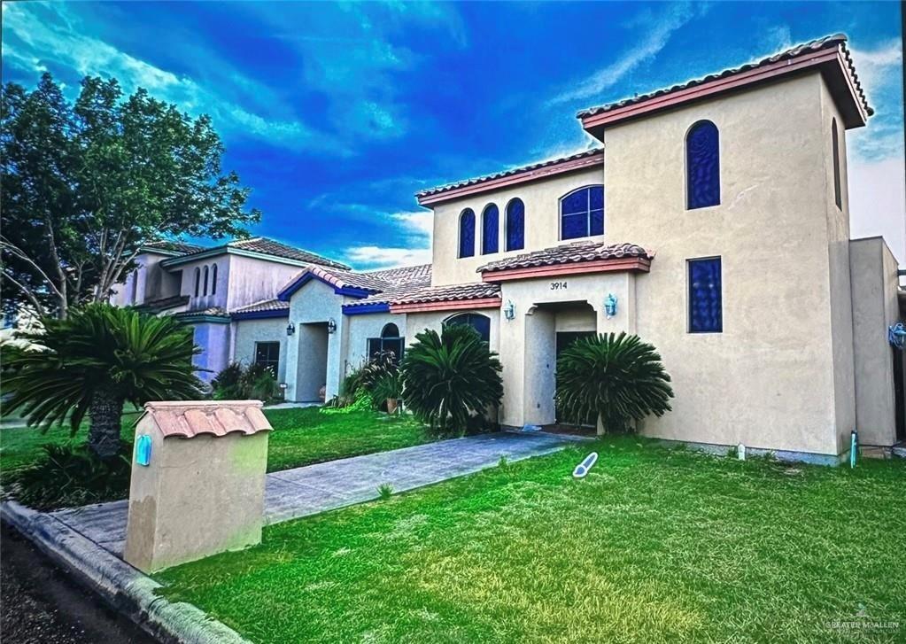 mediterranean / spanish house featuring a front lawn and a garage