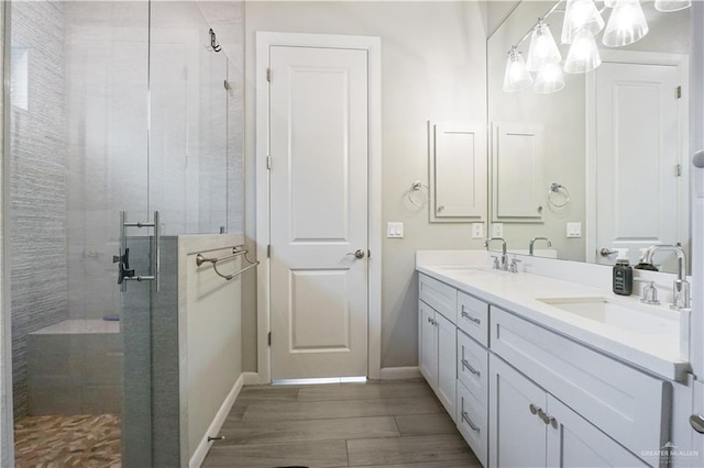2509 Viola St, Mission, TX 78574 - bathroom with a stall shower, wood finished floors, double vanity, and baseboards